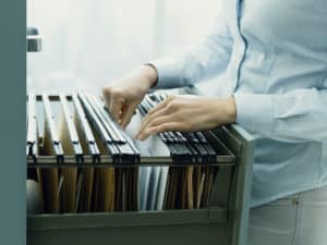 office clerk searching files in the filing cabinet
